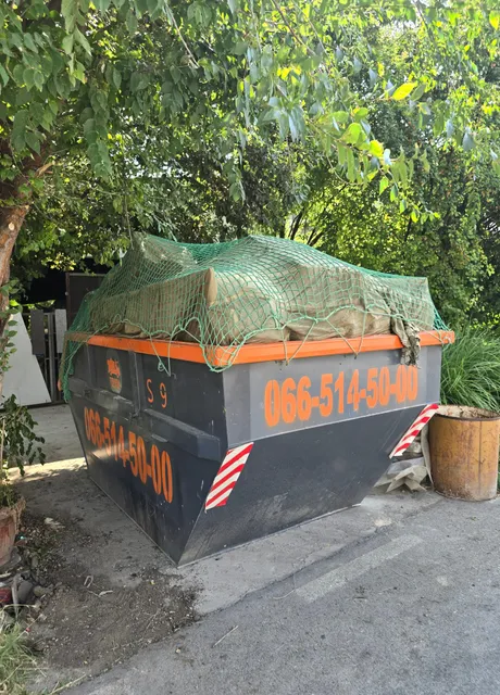Kontejner prekriven mrežom u bašti